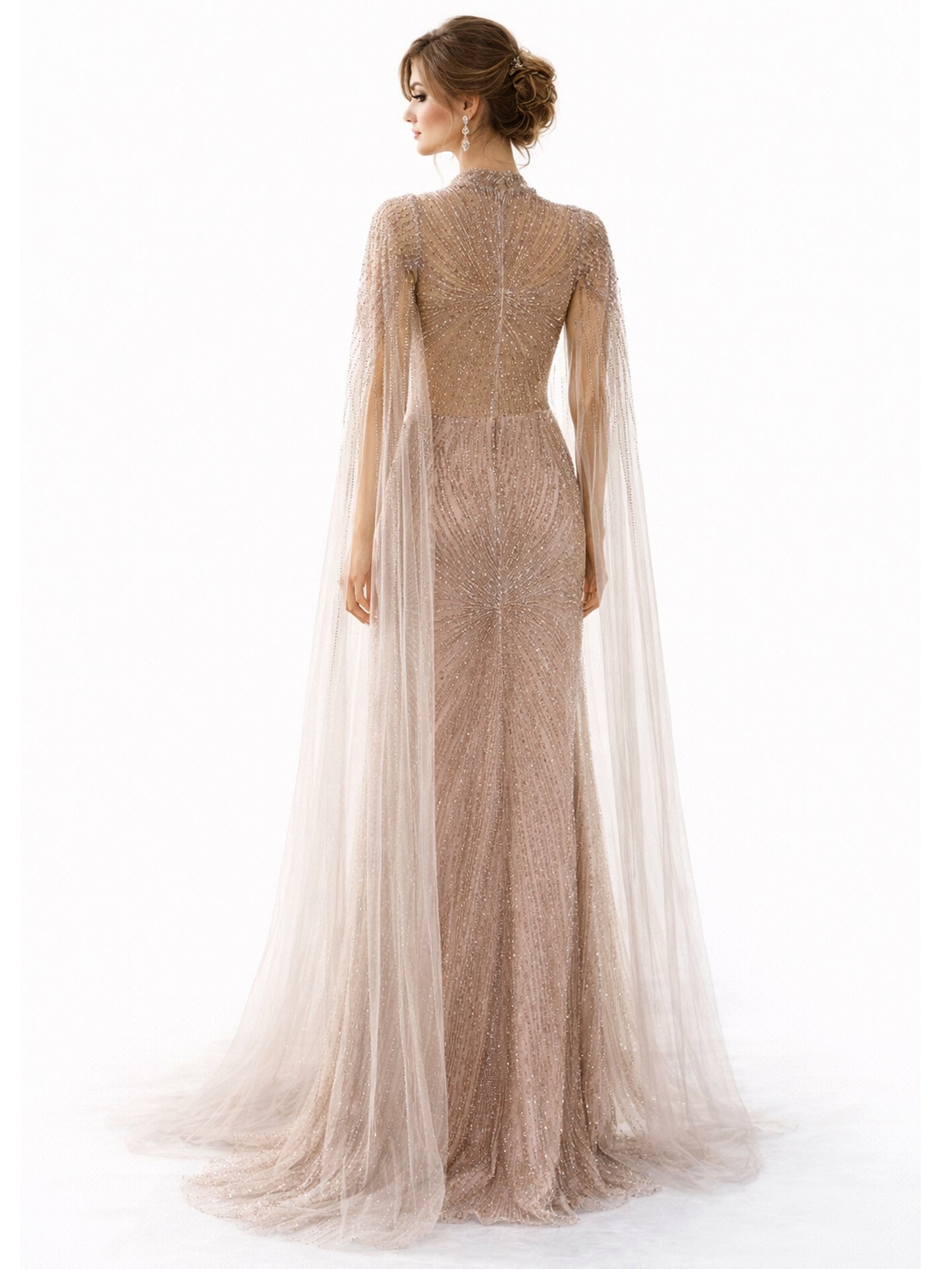 Woman wearing a long, elegant dress with a cape on a white background